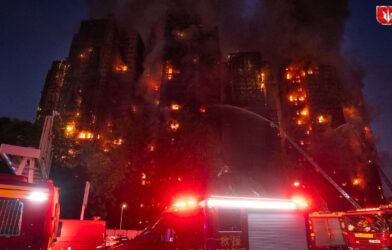 Smoke rising from high-rise buildings in Hong Kong after a massive fire with rescue teams at the scene