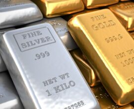Gold bars and silver coins representing rising gold prices and falling silver rates due to expected interest rate cuts