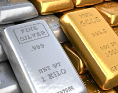 Gold bars and silver coins representing rising gold prices and falling silver rates due to expected interest rate cuts