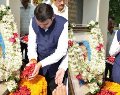 Devendra Fadnavis paying tribute to Dr. Babasaheb Ambedkar by offering flowers and garlanding his photo during a memorial event